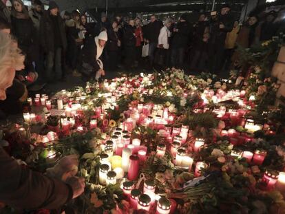 Una mujer enciende una vela en el lugar del atentado que dejó doce víctimas y numerosos heridos en un mercadillo de Navidad de Berlín.