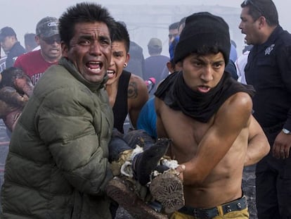 Varios hombres cargan a una víctima de la explosión en Tultepec.