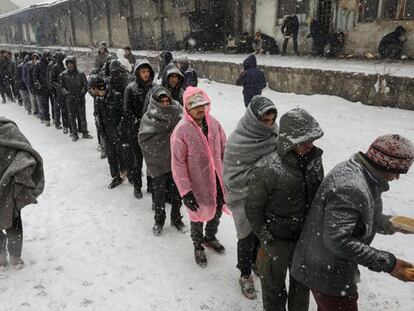 Migrantes hacen cola para recibir comida en Belgrado. Foto: MARKO DJURICA (REUTERS)