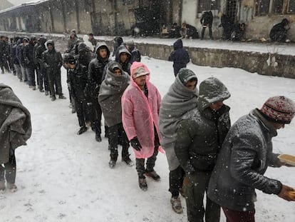 Migrantes hacen cola para recibir comida en Belgrado. Foto: MARKO DJURICA (REUTERS)