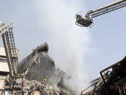 Membros dos serviços de resgate iranianos buscam possíveis vítimas entre os escombros do edifício Plasco.