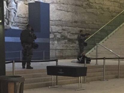El hombre que intentó entrar armado este viernes en el Louvre yace herido en el suelo del museo controlado por dos soldados.