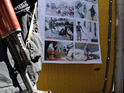 Un hombre armado, junto a un póster de las torturas de Abu Ghraib, este martes en una calle de Saná, la capital de Yemen. En vídeo, el portavoz de la Casa Blanca defiende la operación del Ejército estadounidense.