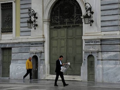 Dos hombres pasan ante la sede del Banco Nacional de Grecia, en Atenas.
