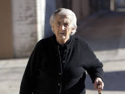 Una anciana pasea por la calle.