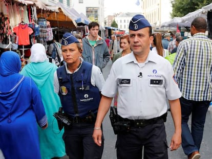 Una pareja de policías patrulla el mercado del barrio de Molenbeek. En vídeo, el primer ministro de Bélgica analiza la seguridad del país un año después de los atentados.