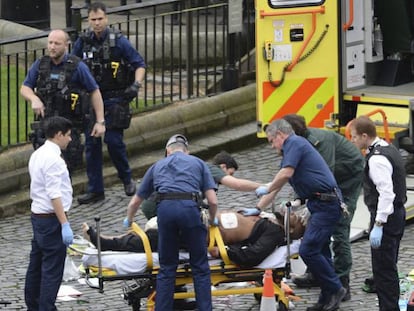 Varias personas asisten a uno de los heridos en los incidentes en el puente londinense de Westminster.