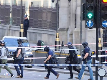 Agentes de la policía antiterrorismo atraviesan la zona acordonada este miércoles en el Puente de Westminster, en Londres, en proximidad de la sede del Parlamento británico.