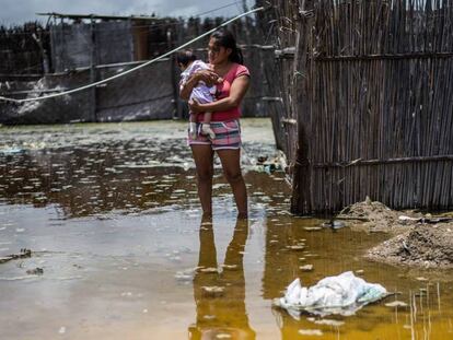 Una mujer y su bebé, en una calle inundada en Piura.