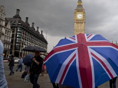 Un ciudadano pasea con un paraguas con la bandera británica, el pasado junio. En vídeo, May anuncia la activación del Artículo 50.