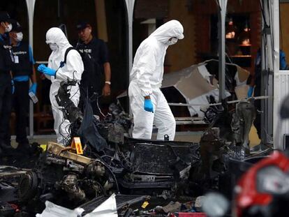 Policías forenses inspeccionan el lugar del doble atentado en Tailandia.