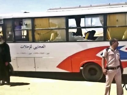 Un policía frente al autobús atacado en Minya (Egipto).