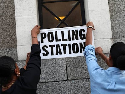 Trabajadores colocan carteles en un colegio electoral en Londres.