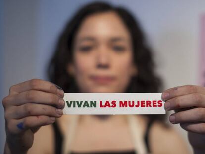 Una colaboradora de 'Vivan las mujeres' sujeta una pegatina contra la violencia machista.
