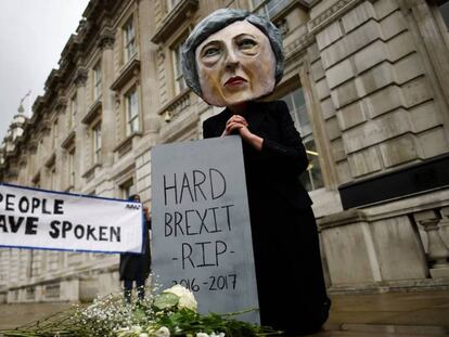 Opositores del Brexit llevan puesto un careto de la primera ministra, Theresa May, este viernes en Londres.