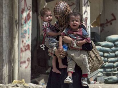 Una mujer iraquí huye con sus hijos de Mosul, este lunes.