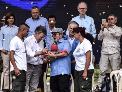Una pareja de guerrilleros entrega a su bebé a Rodrigo Londoño, líder de las FARC, y al presidente colombiano Juan Manuel Santos, durante el acto del final de las armas en Mesetas (Colombia). Vídeo: Colombia muestra su compromiso con la paz ante la ONU.