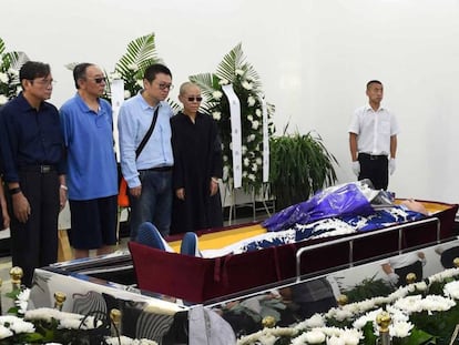 La viuda y otros asistentes al funeral de Liu en una foto difundida por las autoridades.