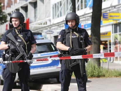 Dos policías custodian la zona acordonada alrededor del supermercado de Hamburgo donde se ha registrado un ataque este viernes.