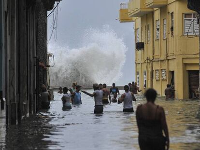 Cubanos caminan por una calle inundada de La Habana.