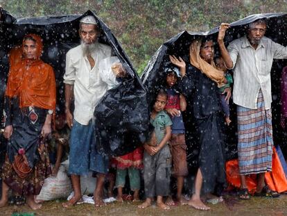 Refugiados rohingya se cubren con un plástico de la lluvia, en el campo de de Cox's Bazar, en Bangladés.