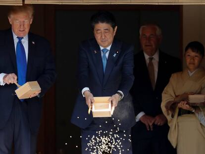 Abe vacía su caja de comida para peces en un estanque del palacio de Akasaka, Tokio.