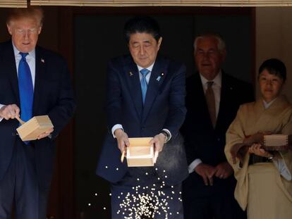 Abe vacía su caja de comida para peces en un estanque del palacio de Akasaka, Tokio.