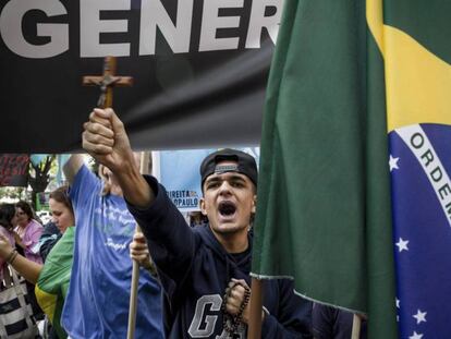 Un joven protesta contra la filósofa feminista Judith Butler, el pasado 9 de noviembre en São Paulo. En vídeo, perfil de Jair Bolsonaro, diputado y candidato presidencial de extrema derecha.