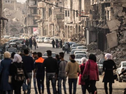 Un grupo de personas camina por una calle de Alepo./ En vídeo, un analista advierte del riesgo de una rápida retirada de las tropas estadounidenses en Siria.