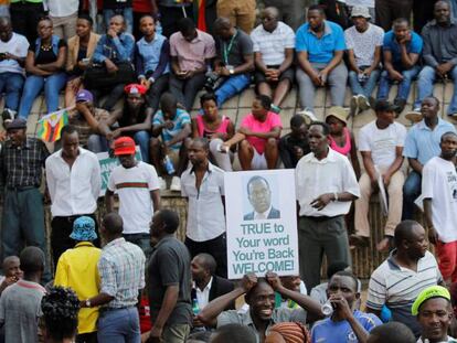 Decenas de zimbabuenses celebran la llegada del exvicepresidente expulsado Emmerson Mnangagwa a Harare este miércoles.