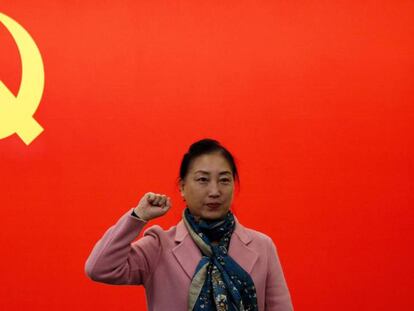 Una mujer, delante de la bandera comunista china en Shanghai.