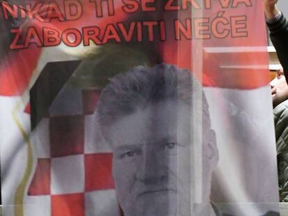 Bosniocroatas sujetan una bandera que muestra a Slobodan Praljak, en Mostar (Bosnia) este miércoles, tras el suicidio del exgeneral.