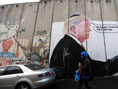 Una mujer camina junto a un graffiti del presidente de EE UU, Donald Trump, en el muro de separación israelí de Belén, este jueves. / Vídeo: Declaraciones del Papa Francisco con respecto a Jerusalén.