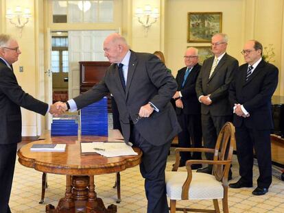 El presidente de la comisión que investigó la pederastia en Australia, Peter McClellan (i), estrecha la mano del gobernador general de Australia, Peter Cosgrove en la presentación del informe.