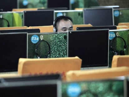 Clientes usan Internet en un cibercafé en Shanghai. En vídeo, declaraciones de Tim Cook, CEO de Apple.