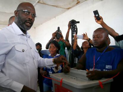 El exfutbolista George Weah (c), ejerce su derecho al voto en la segunda vuelta de las elecciones presidenciales en Monrovia este martes.