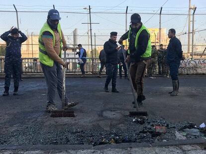 Trabajadores municipales limpian los destrozos dejados por el doble atentado en Bagdad.