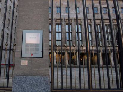 Una instalación artística del alemán Jochen Gerz en la que se lee la palabra 'dinero' en la puerta del Ministerio de Finanzas, en Berlín, este viernes. En vídeo, Merkel habla de los cambios en ministerios claves al anunciar el acuerdo de Gobierno.