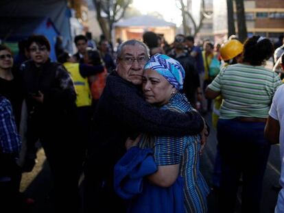 La gente se abraza en la calle de Ciudad de México a la espera de noticias.