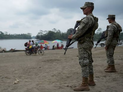 Dos militares colombianos patrullan junto al río Mira, cerca de la frontera con Ecuador.