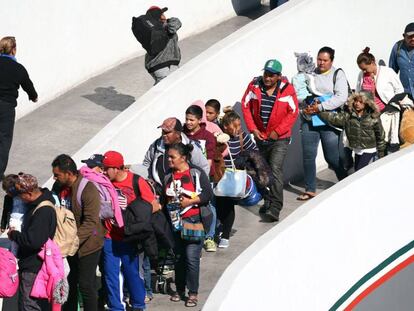 Miembros de la caravana migrante entran en EE UU por el paso de Tijuana, el viernes.