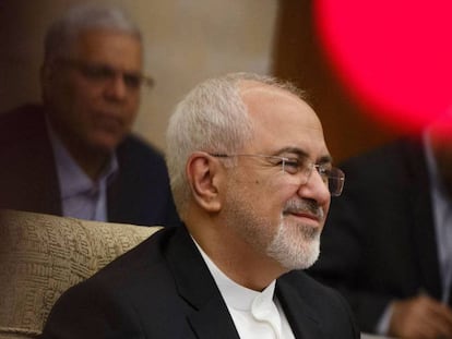 El ministro de Exteriores iraní, Mohammad Javad Zarif, este domingo en Pekín. En vídeo, un grupo de diputados iraníes quema una bandera estadounidense la semana pasada en el Parlamento.