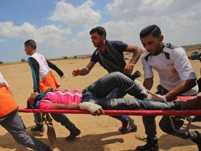 Un palestino herido por las protestas en la frontera de Gaza es evacuado por sanitarios.