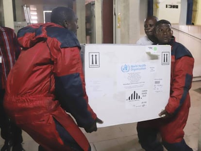 Trabajadores sanitarios transportan vacunas experimentales contra el ébola.