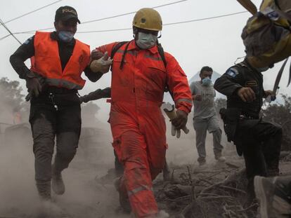 Bomberos y policías evacuan una zona de rescate en Escuintla, Guatemala.