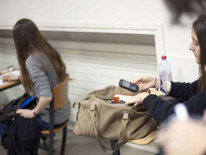 Una joven francesa consulta su móvil en clase.