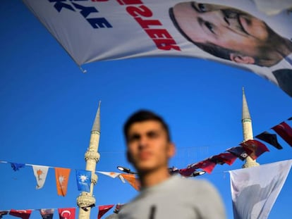 Un joven pasa bajo un cartel electoral del presidente Erdogan en el barrio estambulí de Eminönü. En vídeo, jóvenes candidatos en las elecciones parlamentarias.