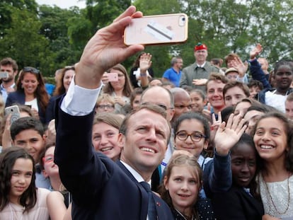 El presidente de Francia, Emmanuel Macron, haciéndose un 'selfie' con unos niños durante la conmemoración del inicio de la resistencia francesa, este lunes en París.