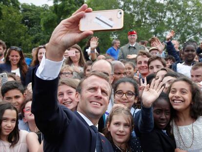 El presidente de Francia, Emmanuel Macron, haciéndose un 'selfie' con unos niños durante la conmemoración del inicio de la resistencia francesa, este lunes en París.