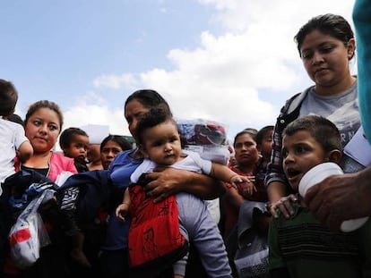 Inmigrantes con hijos, el viernes, en la estación de autobús de McAllen tras ser liberados por la policía fronteriza. En vídeo: Un grupo de activistas pide a Trump el final del hostigamiento a los migrantes.